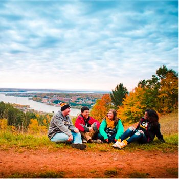 Students sitting on top of the lookout with campus in the background during fall.