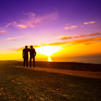 Two people silhouetted in the sunset.