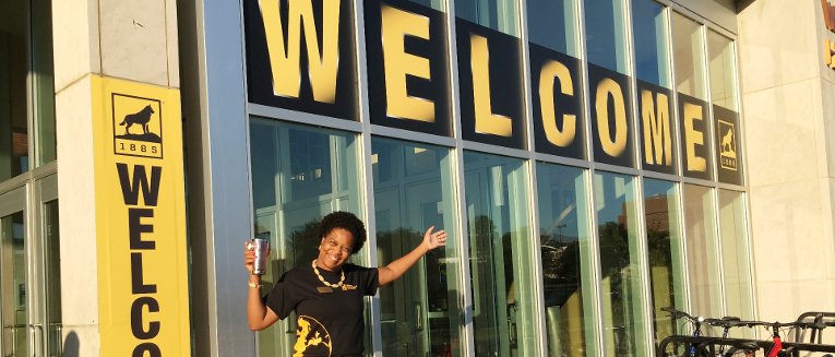 Darnishia Slade in front of the large Welcome sign on Wadsworth Hall.