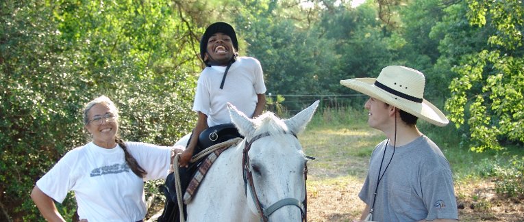 Sanna and a child on a horse.