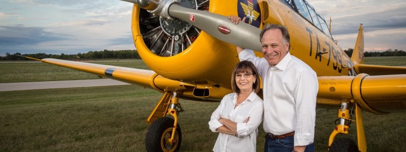 Ron and Linday Staley stand in front of a small airplaine