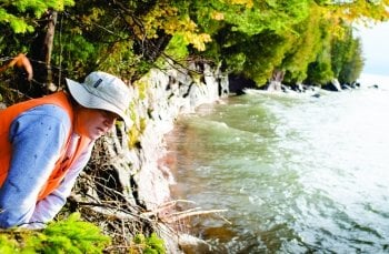 Person leaning over looking at the water.