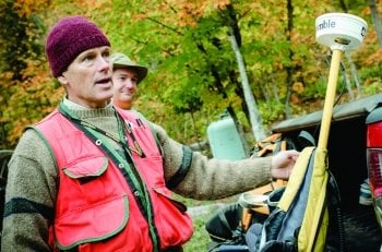 Man standing outside getting equipment from a truck.