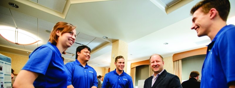 An student group talk with a businessman.