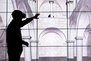 person using virtual reality headset in front of a screen.