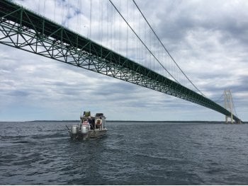 A boat going under the Mackinac Bridge.