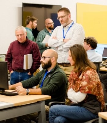 Four people around a computer.