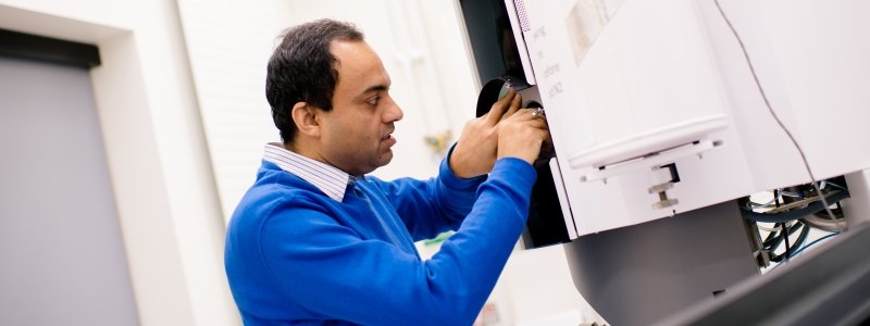 Researcher adjusting the microscope.