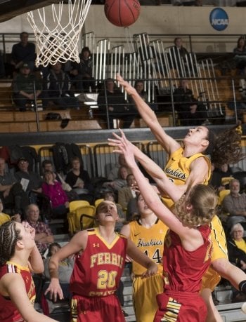 Huskies player shooting a basket surrounded by the other team.