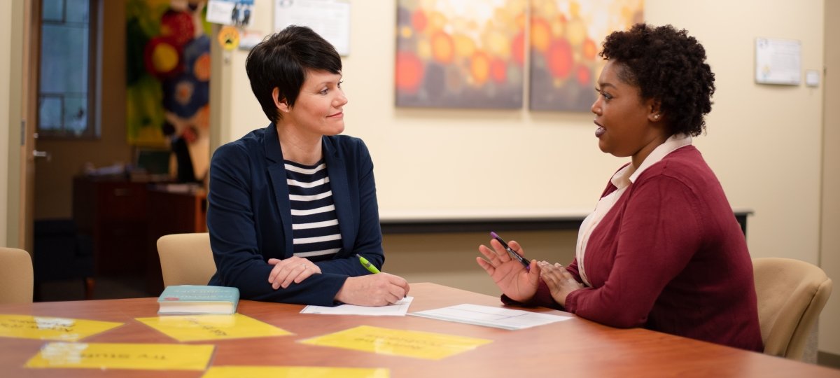 Two people at a table talking.