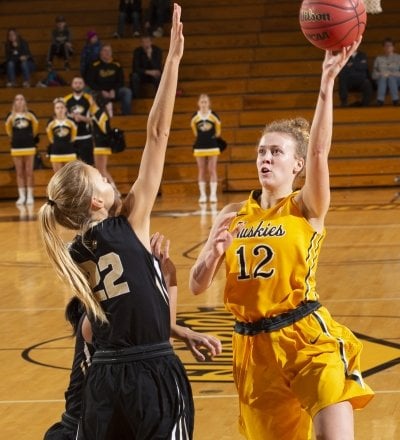 Abbie Botz shooting a basketball around two defenders.