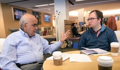 Kanwal Rekhi sitting with a student.