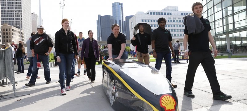 Students walking next to their supermilage vehicle.