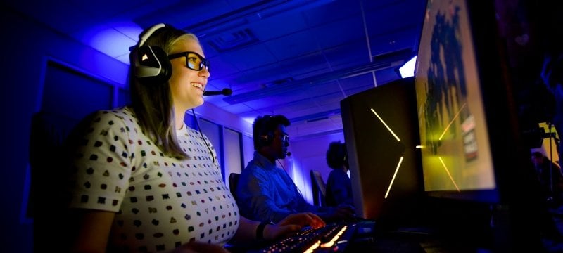 Kaitlyn Roose wearing a headset and looking at a computer screen.