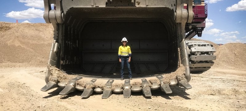 Person standing inside large loader bucket.