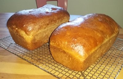 Two loaves of bread on cooling racks.
