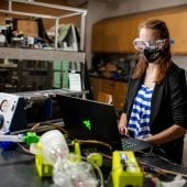 Researcher using a laptop, testing a 3-D printed ventillator.