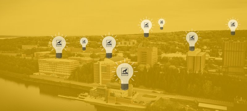 Yellow overlaid photo of campus with lightbulbs on various buildings.