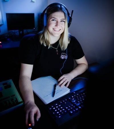 Kaitlyn at a computer with a notebook.