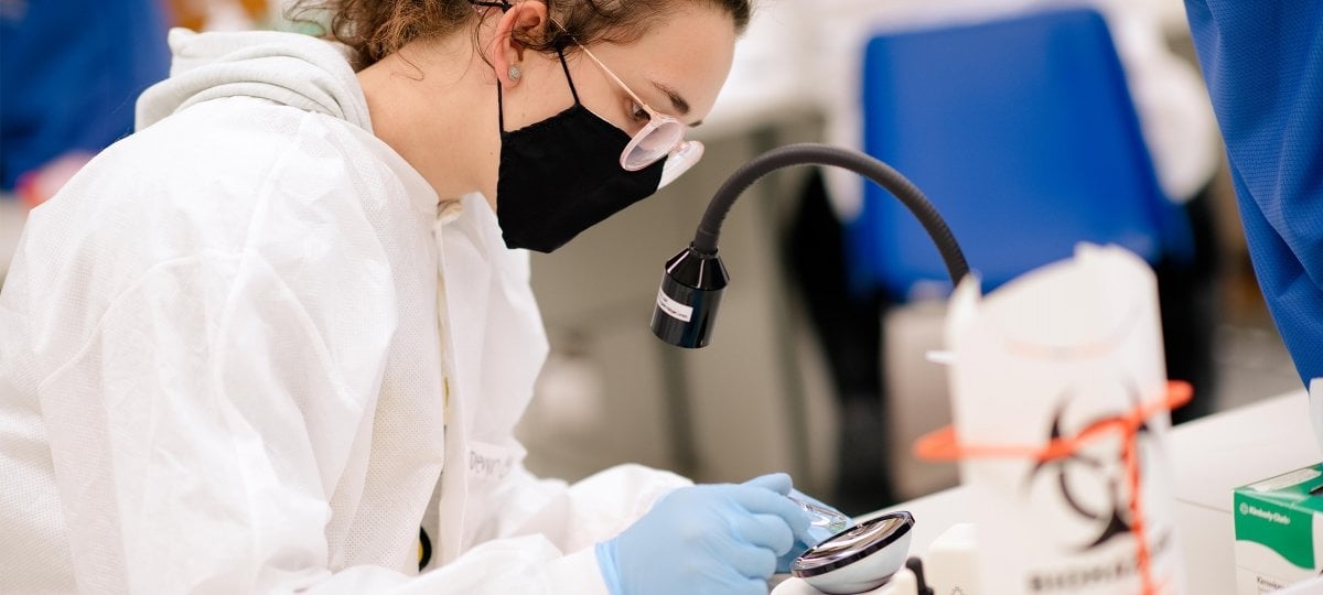 Student looking at a sample in a lab.