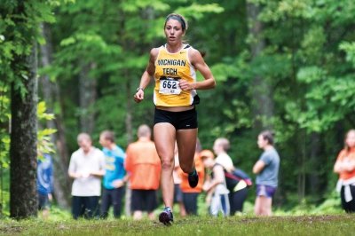 Deedra Irwin running in a Michigan Tech uniform.