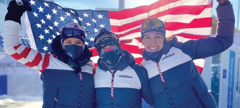 Deedra Irwin and two teammates hold up a US flag at the Olympics.