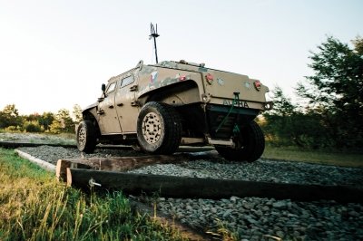 Armored vehicle driving over logs on a course.