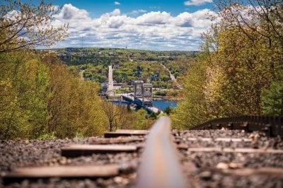 Tram tracks in the foreground lead to a view of the Portage Lake Lift Bridge and Houghton.