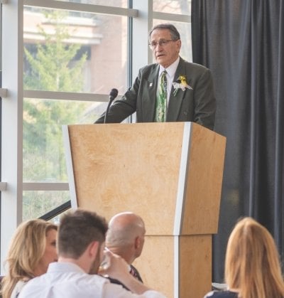 Bill Predebon speaking from a podium.