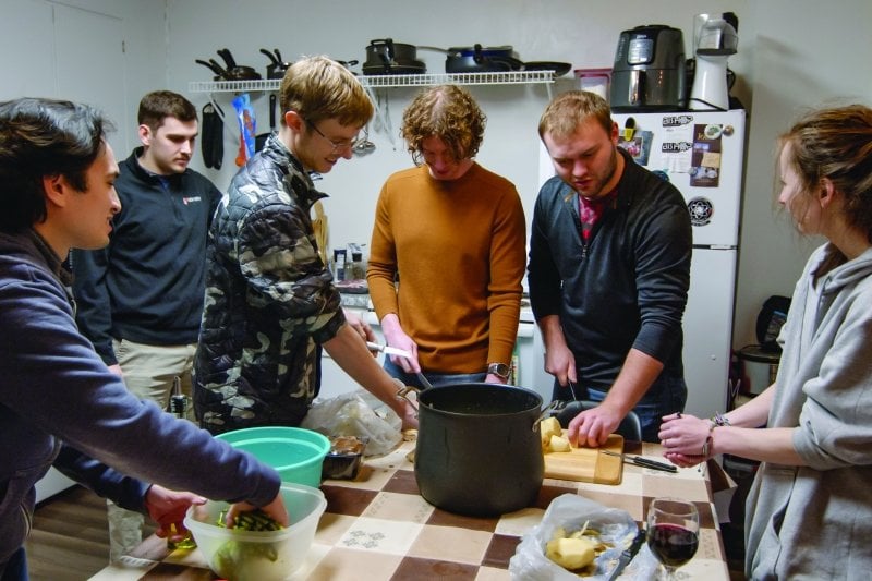The team in a kitchen preparing food.