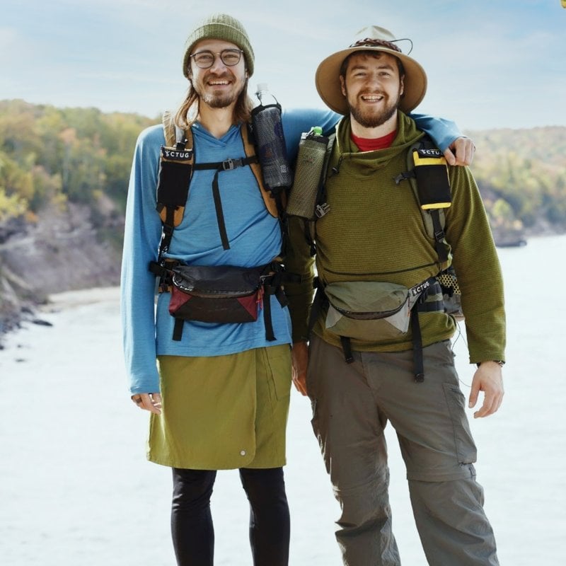 Austin and Nathan posing with some of their gear outdoors.