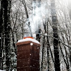 Smoke coming out of a snowy chimney.