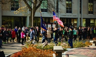 ROTC cadets presneting flags at an outdoor event.