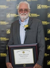 David Reed holding the framed award certificate.