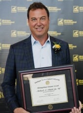 Michael Pulick holding the framed award certificate.