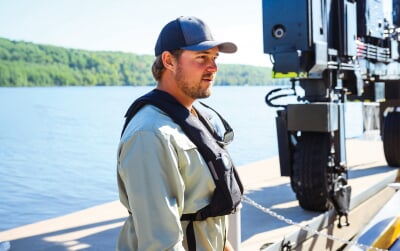 Travis White standing on a dock by the water.
