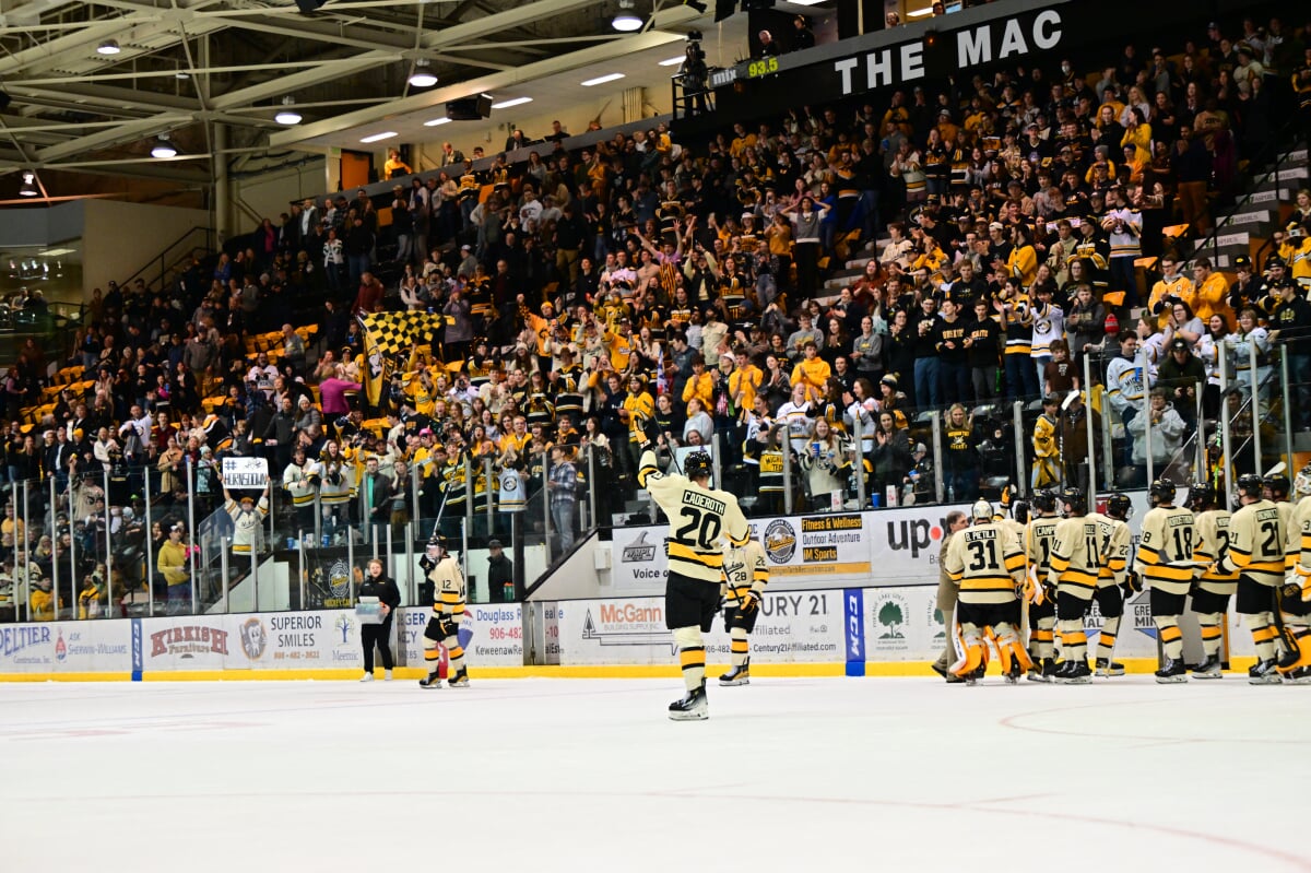 Tech hockey team leaving the ice while one player waves to the Mitch's Misfits section in the stands.