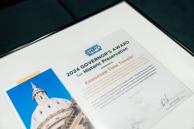 Framed certificate that reads SHPO 2024 Governor's Award for Historic Preservation presented to Keweenaw Time Traveler with smaller print that is not legible.