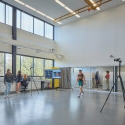 Researchers in a large open room recording a subject walking.