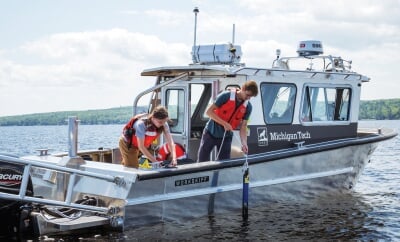 Two students on the RV Soliton on the water.