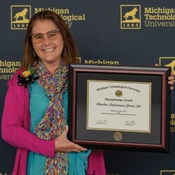 Barbie Laderman-Jones holding a framed award.