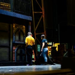Stage crew working on the set on stage.