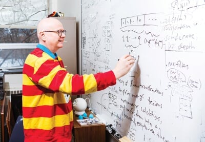 Robert Schneider writing on a whiteboard in his office.