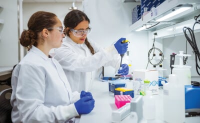 Maria Gencoglu and Samantha Cooper working in the lab.