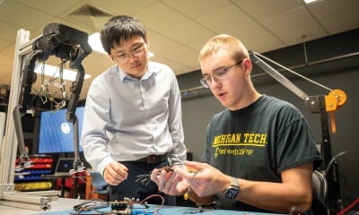 Tan Chen helping a student in the lab.