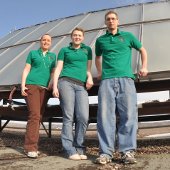 Three students in front of a solar panel.