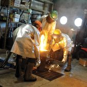 Students pouring molten metal in the foundry.