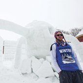Student standing in front of a snow statue.