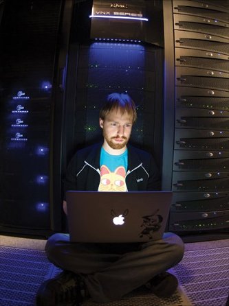 Ryan Sears on his laptop in a server room