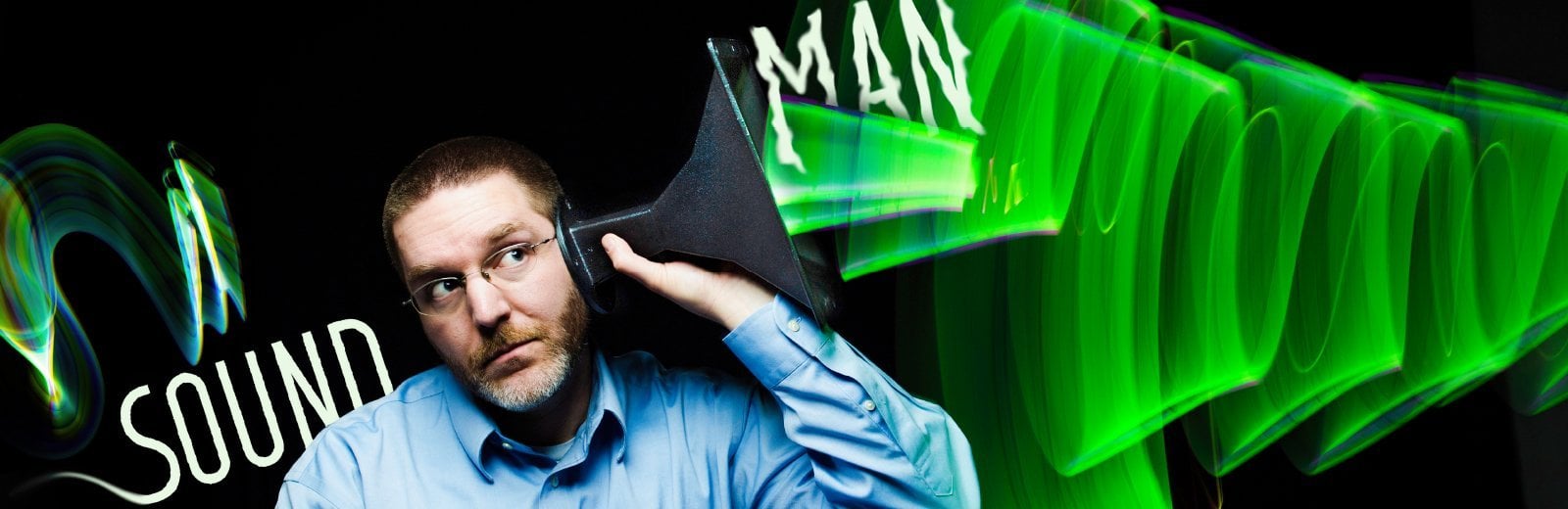 Andrew Barnard holding a funnel to his ear.